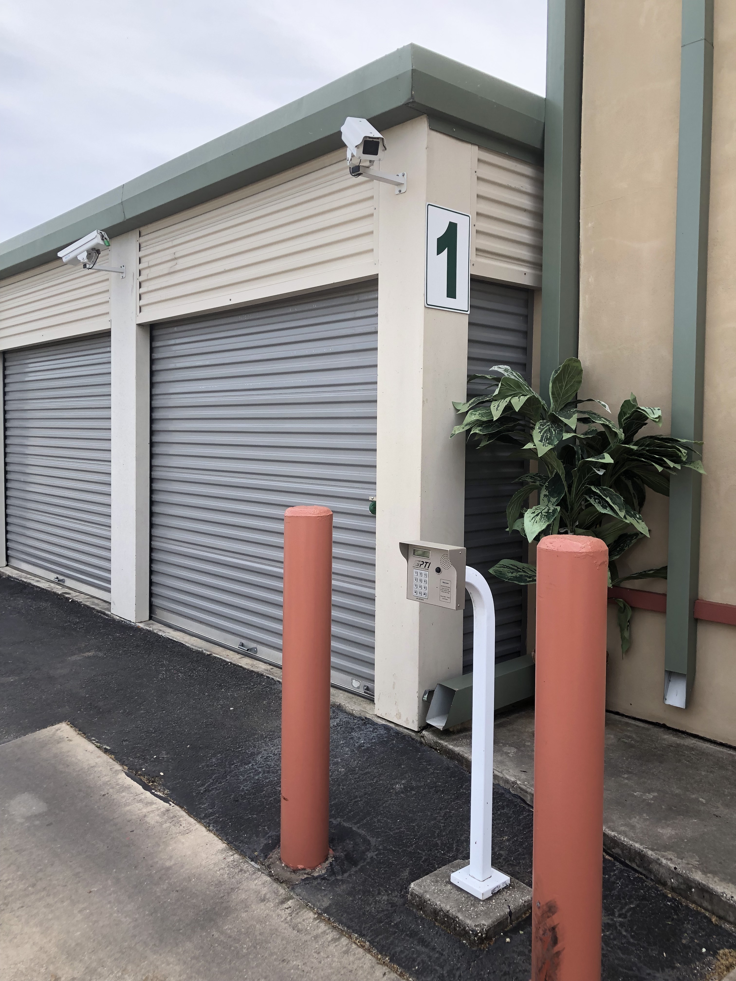 Picture of our climate and non climate mixed building with our exit keypad in front of the iron gate. Security cameras can be seen on top of the building facing each direction